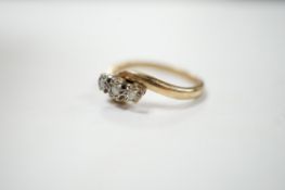 A modern 9ct gold and three stone diamond set cross-over ring, size P/Q, gross weight 3.4 grams.