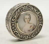 An early 20th century continental white metal circular snuff box, the cover with inset miniature