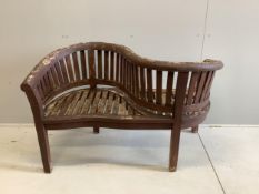 A stained teak garden 'banana' love seat, width 132cm, depth 58cm, height 86cm. Condition - fair