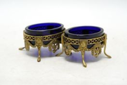 A pair of late 19th/early 20th century continental pierced gilt white metal oval salts, with blue