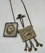 A Greek white metal pendant, embossed with St. George and the dragon, on a chain and a Russian white