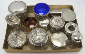 A collection of thirteen assorted late Victorian and later silver topped toilet jars, including blue