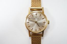 A lady's modern 9ct gold Omega manual wind wrist watch, on an associated 9ct gold bracelet,