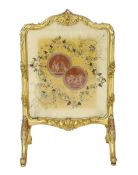 * * A Louis XV style carved giltwood framed fire screen, the silk panel printed with roundels of