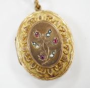 A Victorian engraved yellow metal overlaid, garnet and seed pearl set oval locket, 37mm. Condition -