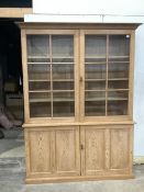A Victorian pitch pine bookcase / cupboard with compartmented panelled base, width 168cm, depth