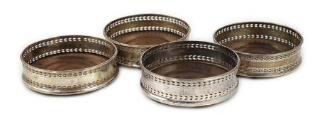 A set of four George III pierced silver mounted wine coasters, John Younge & Co, with engraved