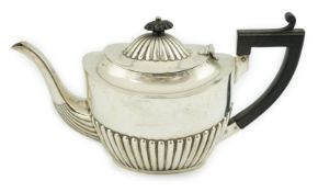 A late Victorian demi-fluted silver oval teapot, Nathan & Hayes, Chester, 1900, gross weight 17.1oz.