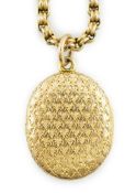 A late Victorian engraved gold oval locket, on a 10k chain, locket 28mm, chain 40cm, gross weight