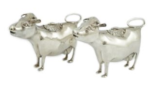 A pair of Elizabeth II silver cow creamers, by Heming & Co, each with hinged cover and housefly