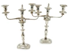 A pair of Elizabeth II silver two branch two light candelabra, by James Dixon & Sons, with scroll