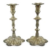 A pair of early George III cast silver candlesticks, by William Cafe, with waisted knopped stems, on