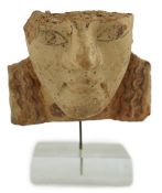 An Etruscan terracotta antefix, modelled as a head with polychrome painted features, 6th-5th century