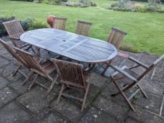 A Lindsay teak extending garden table and eight folding chairs. Condition - weathered, otherwise