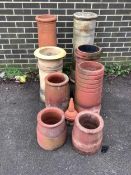 Eight assorted ceramic chimney pots and a finial, largest height 93cm. Condition - weathered