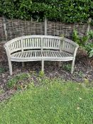 A curved teak bench, 160cm, 82cm high. Condition - weathered, otherwise good