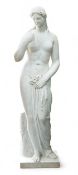 After the Antique. A large carved marble figure of Venus, standing beside a tree trunk, 141cm