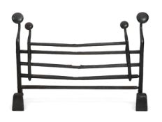 A 17th century French iron adjustable grate, with roundel finials and stylised scroll feet, width