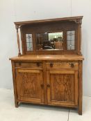An Arts and Crafts oak sideboard, with stained glass raised mirrored back, width 122cm, depth