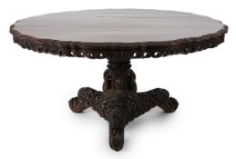 A 19th century Anglo-Indian hardwood foliate carved tilt top centre table, with serpentine