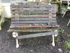 A Victorian slatted teak garden bench, raised on white painted cast iron ends, width 109cm, depth