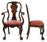 A set of twelve Queen Anne revival walnut dining chairs, including two carvers, with solid vase
