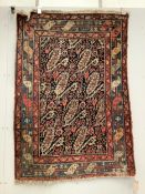 A Persian black ground rug, 140 x 97cm. Condition - faded and worn
