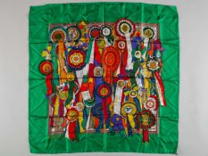 A Gucci ladies silk scarf featuring a colourful design of horse show winners' rosettes.
