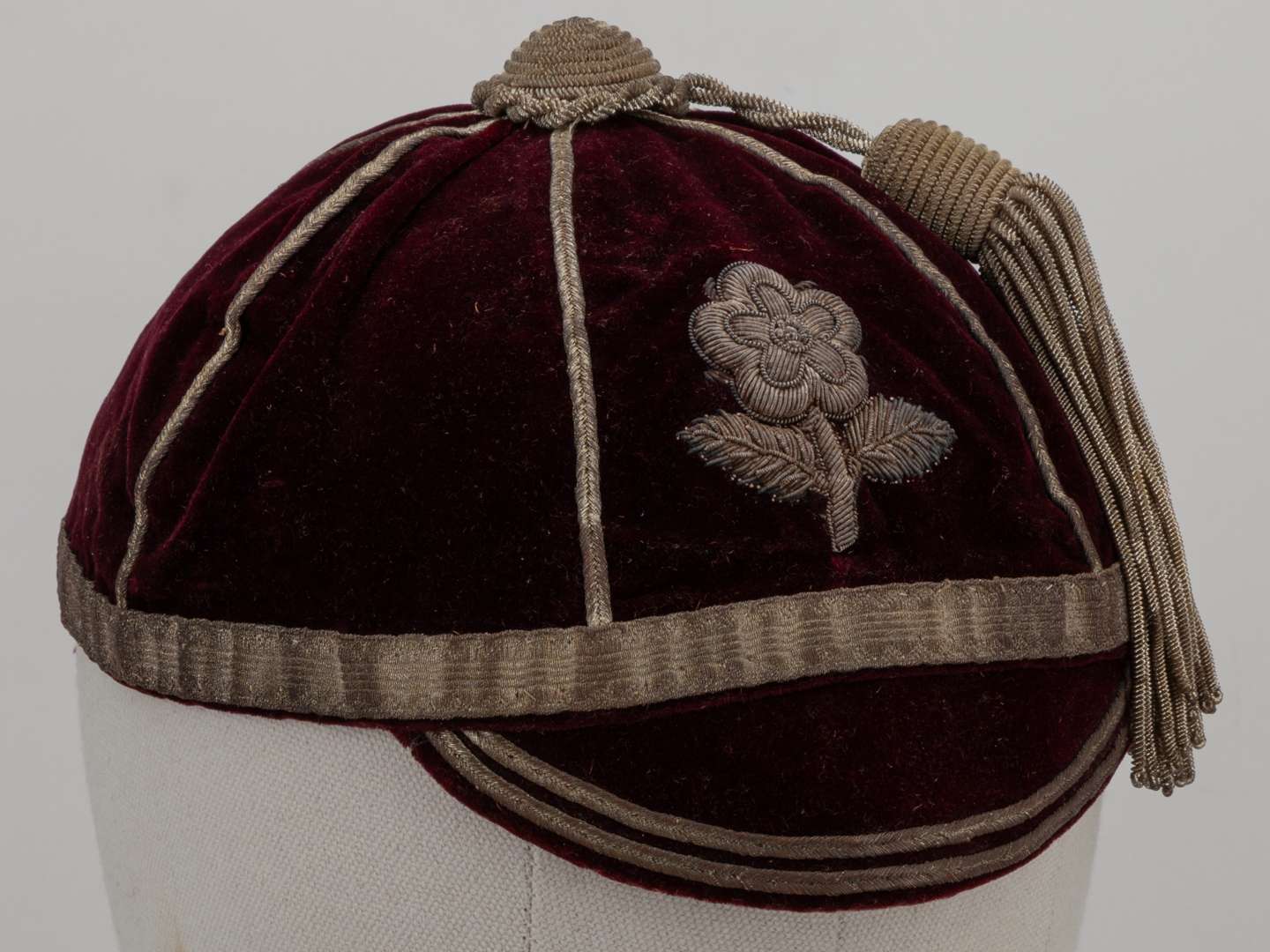 A maroon Rugby Union international cap, maroon velvet with silver tassel and embroidered crest