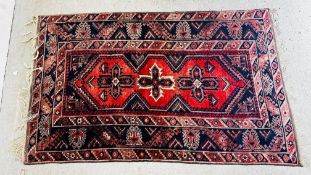 A CAUCASIAN RUG, THE CENTRAL CRUCIFORM MOTIF, DARK BLUE FIELD AND WIDE GUARD STRIPES.