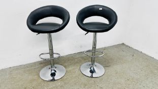 A PAIR OF CHROMIUM PILLAR RISE & FALL BREAKFAST STOOLS WITH FAUX GREY LEATHER SEATS.