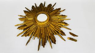 A VINTAGE SUNBURST MIRROR IN A CARVED GILDED WOOD MOUNT (A/F) DIAM 65CM.