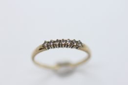 A LADY'S 9CT GOLD RING SET WITH SEVEN SMALL DIAMONDS, SIZE T/U.