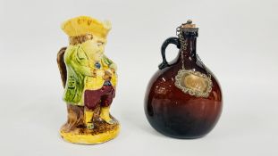 AN ANTIQUE CERAMIC TOBY JUG AND A BROWN GLASS GIN FLASK.