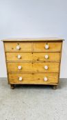 ANTIQUE WAXED PINE TWO OVER THREE DRAWER CHEST WITH WHITE CERAMIC KNOBS, STANDING ON TURNED LEGS,