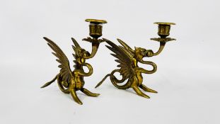 A PAIR OF VINTAGE BRASS GRIFFIN CANDLE STICKS.