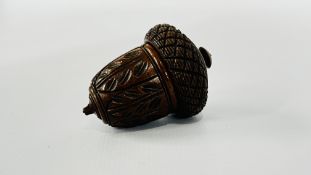AN ANTIQUE NUTMEG GRATER, CARVED IN THE FORM OF AN ACORN WITH A SCREW THREADED COVER. L 7.5CM.