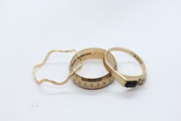 A 9CT GOLD RING OF WAVY FORM, SIZE N/O, A 9CT GOLD RING SET WITH BLACK ONYX AND SINGLE WHITE STONE,