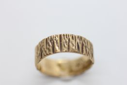 A 9CT GOLD WEDDING BAND OF BARK DESIGN, SIZE R/S.