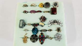 A PAD CONTAINING 26 ASSORTED COSTUME JEWELLERY RINGS.