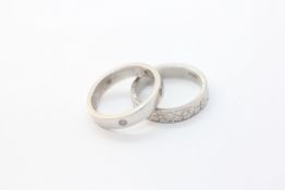 A PLATINUM BAND RING SET WITH FIVE SMALL DIAMONDS AND A PLATINUM WEDDING BAND.
