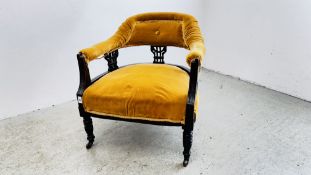 A PERIOD LOW CHAIR UPHOLSTERED WITH A MUSTARD VELOUR, ON CERAMIC CASTERS H 68CM.