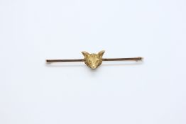 A 9CT GOLD BAR BROOCH WITH FOX HEAD DETAIL.