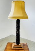 AN UNUSUAL HAND CARVED TABLE LAMP THE COLUMN DETAILED WITH THREE FACES WITH CREAM SHADE - SOLD AS