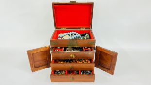 A VINTAGE CHINESE HARD WOOD JEWELLERY CHEST WITH BRASS DETAIL AND CONTENTS TO INCLUDE STONE SET