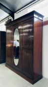 A LARGE EDWARDIAN MAHOGANY TRIPLE WARDROBE WITH CENTRAL OVAL MIRRORED DOOR W 197CM D 57CM H 213CM -