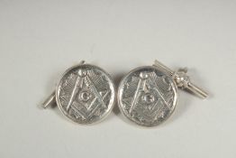 A pair of masonic cufflinks in a box.