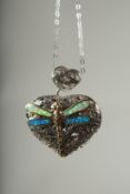 A silver heart shaped locket and chain set with opals in a box.