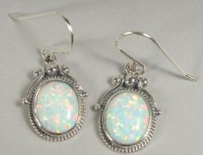A pair of silver Victorian style opal earrings in a box.