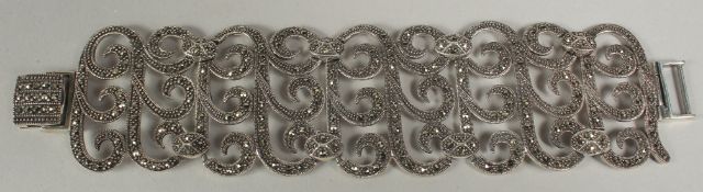 A silver wide pierced bracelet in a box.
